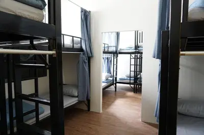 a dorm room with bunk beds and a mirror at Krit Hostel in Bangkok