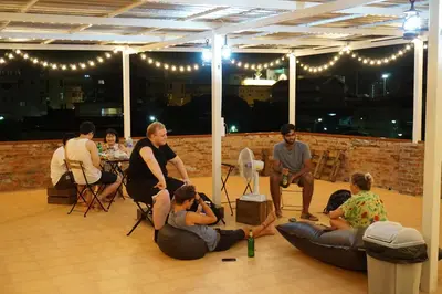 a group of people sitting around in a room at Krit Hostel in Bangkok