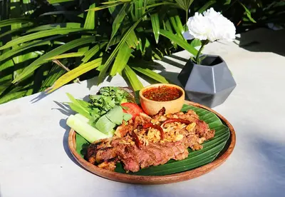 a plate of food with meat and vegetables on a table at W Station in Bangkok