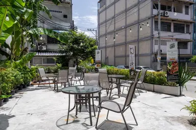 a group of chairs and tables on a sidewalk at W Station in Bangkok