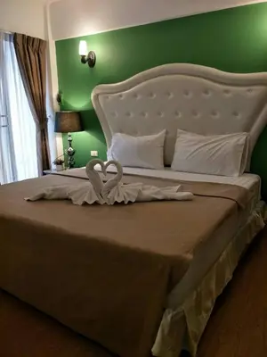 a bedroom with a large bed with a white headboard at Sudyod Apartment in Bangkok