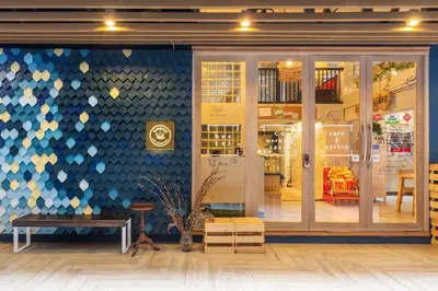 a store front with a blue and white wall at Kinnon Deluxe Hostel Coworking Cafe in Bangkok