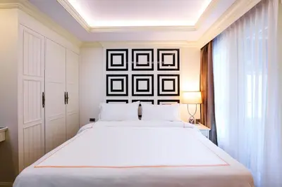 a bedroom with a large white bed and a window at The LA49 Hotel in Bangkok