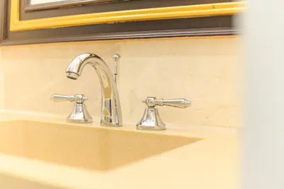 a bathroom sink with two faucets on it at The LA49 Hotel in Bangkok