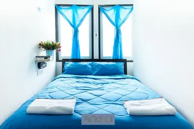 a bedroom with a blue bed with blue curtains at Zee Thai Hostel in Bangkok