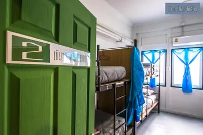 a green door in a room with bunk beds at Zee Thai Hostel in Bangkok
