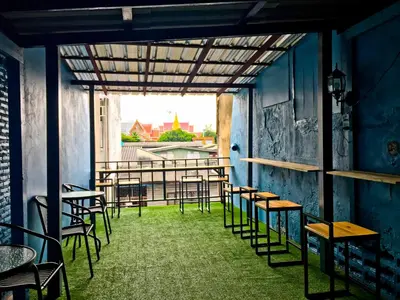 a room with chairs and tables and a window at Zee Thai Hostel in Bangkok