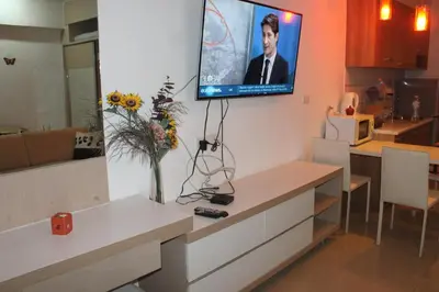 a living room with a tv hanging on the wall at Studio in Haven in Bangkok