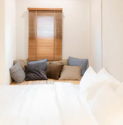 a room with a bed with pillows and a window at Hotel PaPa Bangkok Siriraj in Bangkok