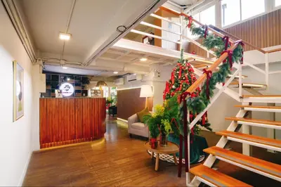 a living room with a staircase with a christmas tree at Hotel PaPa Bangkok Siriraj in Bangkok