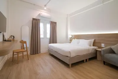 a hotel room with a bed and a couch at Hotel PaPa Bangkok Siriraj in Bangkok