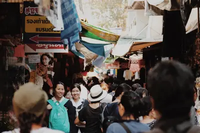 a crowd of people walking down a crowded street at Theatre Residence in Bangkok