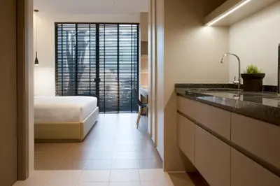 a bedroom with a bed and a bathroom with a sink at Theatre Residence in Bangkok