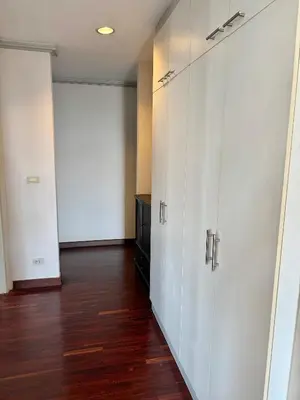 an empty room with white doors and wooden floors at Samsen Suites Spacious 2BR Contemporary Thai Style in Bangkok