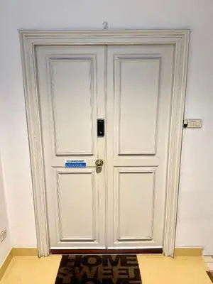 a white door in a room with a rug at Samsen Suites Spacious 2BR Contemporary Thai Style in Bangkok