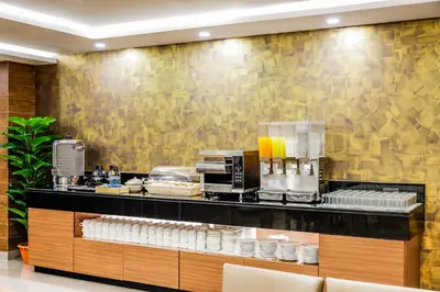 a buffet line in a restaurant with a yellow wall at Livotel Hotel Hua Mak Bangkok in Bangkok