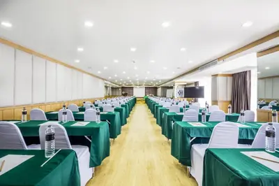 a conference room with green tables and white chairs at Livotel Hotel Hua Mak Bangkok in Bangkok