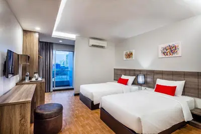 a hotel room with two beds and a television at Livotel Hotel Hua Mak Bangkok in Bangkok