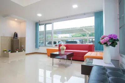 a living room with a red couch and a table at Jr Mansion On Nut Soi 25 in Bangkok