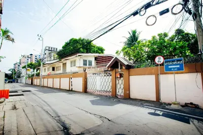 a street with a fence and a house at Grand Residence Ngamwongwan 19 in Nonthaburi
