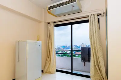 a room with a refrigerator and a large window at Grand Residence Ngamwongwan 19 in Nonthaburi