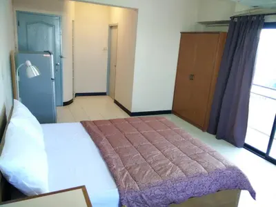 a bedroom with a bed and a refrigerator at Grand Residence Ngamwongwan 19 in Nonthaburi