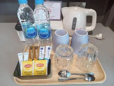 a tray with bottles of water and glasses and spoons at Collection O Pratunam 19 Hotel in Bangkok