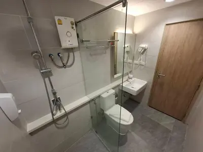a bathroom with a toilet and a glass shower stall at Collection O Pratunam 19 Hotel in Bangkok