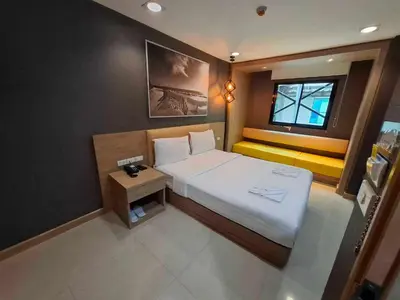 a small bedroom with a bed and a window at Collection O Pratunam 19 Hotel in Bangkok