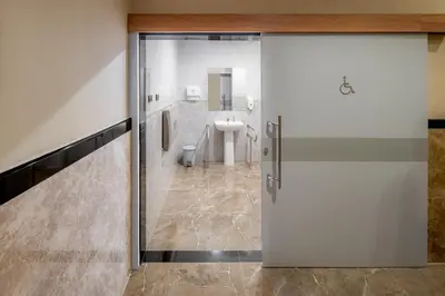 a bathroom with a toilet and a sink at Alexander Hotel in Bangkok