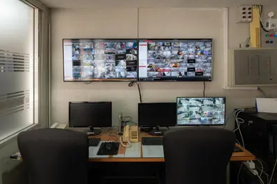 an office with two monitors and a desk with two computers at Alexander Hotel in Bangkok