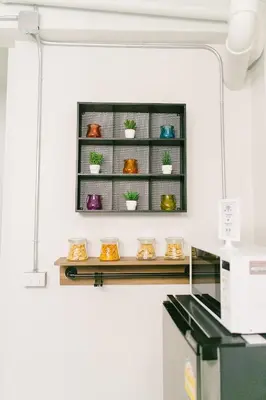 a shelf with potted plants on it in a kitchen at Diff Hostel in Bangkok