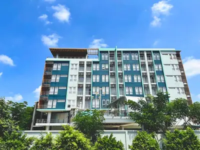 a tall building with trees in front of it at Anna-Nava Pakkret Hotel in Nonthaburi