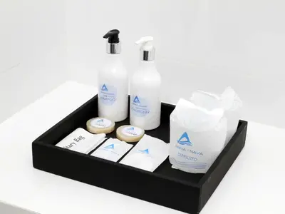 a black tray with bottles and other products on a counter at Anna-Nava Pakkret Hotel in Nonthaburi