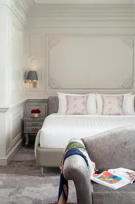 a bedroom with a bed and a person laying on a couch at Kingston Suites Bangkok in Bangkok