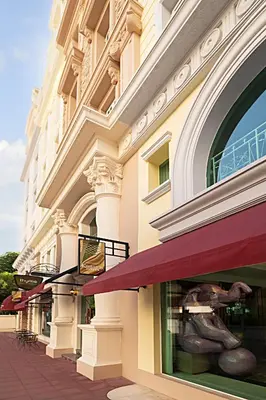 a facade of a building with red awnings at Kingston Suites Bangkok in Bangkok