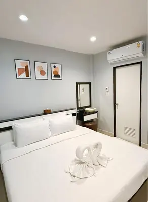 a bedroom with a white bed with flowers on it at Sampheng Apartment in Bangkok