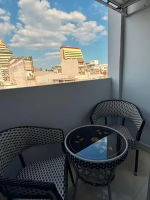 two chairs and a table on a balcony with a view at Sampheng Apartment in Bangkok