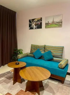 a living room with a blue couch and two tables at Sampheng Apartment in Bangkok