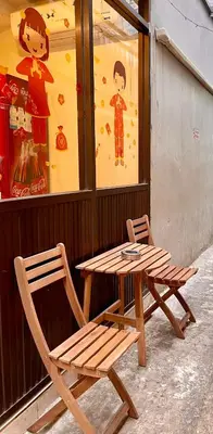 a wooden table and a chair sitting next to a table and a table at Sampheng Apartment in Bangkok