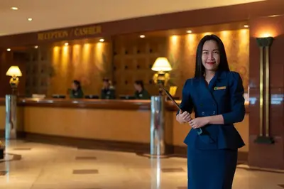 a woman in a hotel lobby holding a wand at The Emerald Hotel in Bangkok