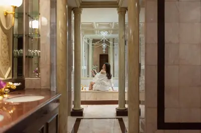 a woman in a bathroom looking at herself in the mirror at The Emerald Hotel in Bangkok