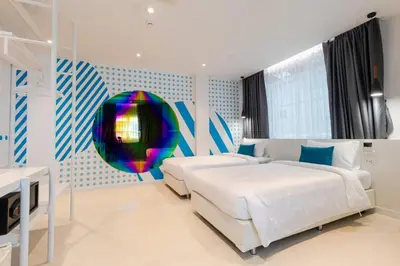 a bedroom with two beds and a colorful wall at Budacco The Living Place in Bangkok