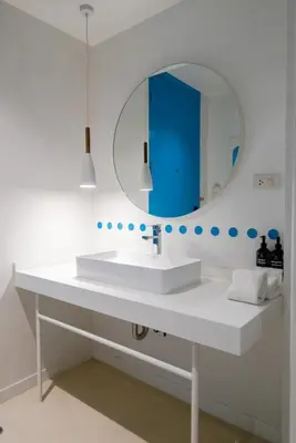 a bathroom with a white sink and a mirror at Budacco The Living Place in Bangkok