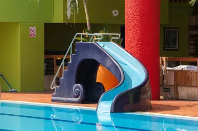a blue slide next to a swimming pool at The Aiyapura Bangkok in Bangkok