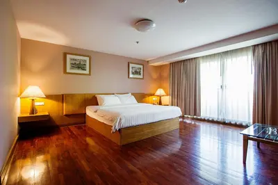 a bedroom with a large bed and a large window at The Aiyapura Bangkok in Bangkok