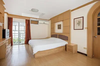a bedroom with a white bed and a window at The Aiyapura Bangkok in Bangkok