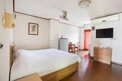 a bedroom with a bed and a flat screen tv at The Aiyapura Bangkok in Bangkok