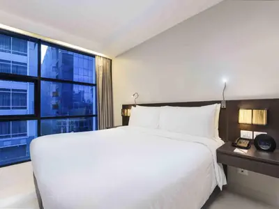 a bedroom with a large white bed and a large window at Maitria Hotel Sukhumvit 18 Bangkok – A Chatrium Collection in Bangkok