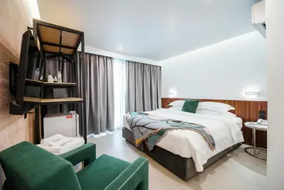 a hotel room with a bed and a couch at Grand Inn Hotel in Bangkok